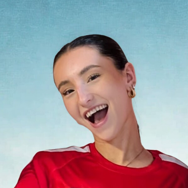 Kayla, entraîneuse des Little Kickers, se tient à l'extérieur.